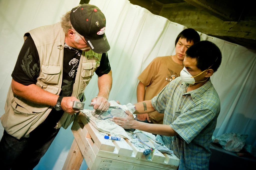 Photo of Eugene helping two youth carve